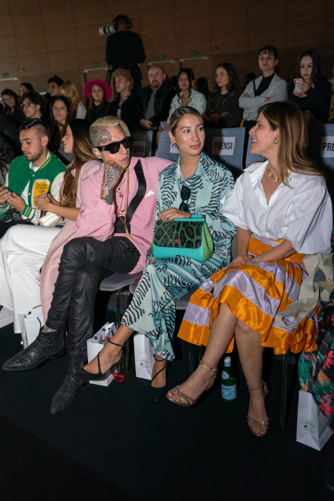 Chris Lavish and Camila Villamiln with stylist and director Loren Barake front row at Bogotá Fashion Week 2022.  Bright colours and statement sleeves for a comfortable classy look was a favorite with this crowd.